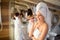 Pretty woman with towel on head using facial brush