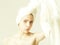 Pretty woman unwinding white, bath towel from head