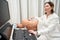 Pretty woman uzist examines patient abdominal cavity on modern apparatus