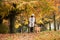 Pretty woman walking her Golden Retriever Dog in a park with Fall colors