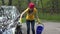 Pretty woman washes her car with sponge in open air.