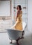 Pretty woman wearing bathrobe in bathroom. Beautiful woman relaxing in bathtub. Sensual charming young woman in bathtub