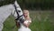 Pretty woman in a wedding dress in a pasture in the afternoon stroking her horse