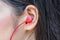 Pretty women or girl using red ear headphone to listen song.