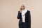 Pretty young arabic muslim woman talking on phone isolated on studio backround