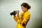 Pretty young Asian businesswoman in yellow suit holding a binoculars.
