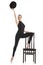 Pretty young ballerina posing with chair. Isolated