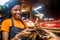 Pretty young black woman selling tomatoes in a local african market receiving payment via mobile phone transfer giving a thumbs up