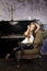 Pretty young blond real girl at piano in old-style rusted interior, vintage concept