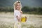 Pretty young blonde woman with camomiles in white blooming field. girl in camomile wreath