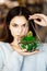 Pretty young brunette girl holding a beautiful terrarium with cactus in her hands. Time for gifts