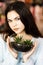 Pretty young brunette girl holding a beautiful terrarium with cactus in her hands. Time for gifts