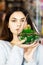 Pretty young brunette girl holding a beautiful terrarium with cactus in her hands. Time for gifts