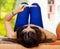 Pretty young brunette woman lying down holding up pregnancy home test in front, as seen from behind head, bookshelves