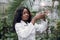 Pretty young confident african woman scientist biologist in white coat pouring liquid from flask into test tube, making