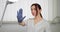 Pretty Young Confident Woman Cosmetologist Doctor In White Coat And Blue Gloves, posing at modern light beautician