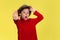 Pretty young curly boy in red wear on yellow studio background. Childhood, expression, fun.
