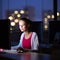 Pretty, young female college student using a desktop computer/pc in a college library (shallow DOF; color toned image)