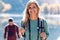 Pretty young female hiker smiling while looking at camera in front of lake