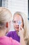 pretty, young female patient having her eyes examined by an eye doctor