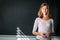 Pretty, young female student/young teacher in front of a blackboard