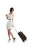 Pretty young girl carries a suitcase on wheels. Funny girl with