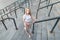 Pretty young girl with a pink kick scooter stands on the background of a modern architecture, view of the camera, top view.