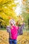 Pretty young girl throws leaves in the park