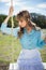 Pretty young model relaxing sitting on swing