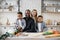 Pretty young mother, father and two children sons preparing salad with fresh vegetables