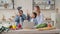 Pretty young mother and two children sons preparing salad with fresh vegetables