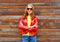 Pretty young smiling woman wearing a red leather jacket in autumn over wooden textured