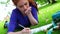 Pretty young student lying on the grass studying