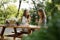 Pretty young two women sitting outdoors in park drinking wine