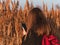 Pretty young woman in black coat with backpack smartphone on pampas grass sunset sky dry reeds Millennial long hair girl