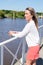 Pretty young woman blonde on water side lake in summer vacation