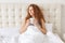 Pretty young woman with curly hair has morning aromatic coffee i