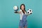 Pretty young woman football fan support favorite team with soccer ball, world globe isolated on blue turquoise