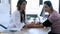 Pretty young woman gynaecologist checking the blood pressure of her pregnant patient in the clinic.