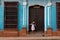 A pretty young woman with hat located at the door of an old colonial house in the colonial town of Trinidad Cuba