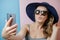 Pretty Young woman in hat and sunglasses with phone. Summer concept