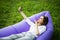 Pretty young woman lying on inflatable sofa lamzac send kisses on video call or take selfie while resting on grass in park on the