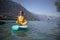 Pretty, young woman paddling on a paddle board on a lake