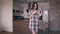 Pretty young woman in plaid shirt dancing at home. Steadicam 4K shot