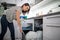 Pretty, young woman putting dishes in the dishwasher