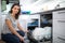 Pretty, young woman putting dishes in the dishwasher