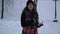 Pretty young woman runs toward the camera throwing snow balls in snow covered park. The girl in winter coat and hat have