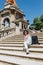 Pretty young woman sitting on the staircase in front of the fountain