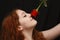 Pretty young woman smelling rose