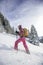 Pretty, young woman snowshoeing in high mountains